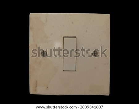 Used single electrical wall switch isolated on black background. Minimal home electricity control device with copy space for electrical installation, maintenance, home improvement, and safety concepts.