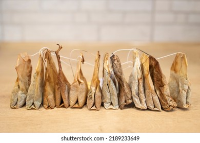 Used Tea Bags Are Stored In A Row On A White And Wooden Background. Tea Bags For Reuse. Recycling Is About Ecology. Used Tea Bags For Re-using As A Compress, To Acidify Oil, To Revitalize Puffy Eyes