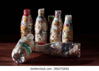 Used transparent plastic bottles are filled with various plastic waste. Concept of dense packaging of waste for recycling.