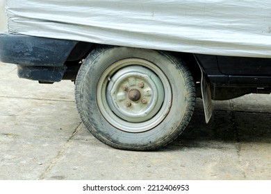 Used Tyre On Blue Car Wheel With Cover Car Body. Deflated, Damage