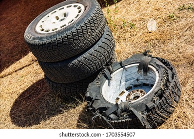 Used White Car Wheels Tire Wheels After Car Race In A Field On Dried Yellow Grass