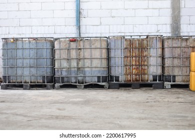 Used White Color IBC Outside The Building.  Liquid Goods Storage Tank