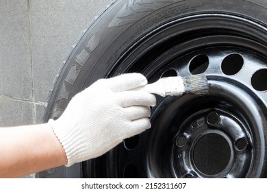 Used winter studded tire for car.Studded wheel for car close-up. Painting a car disc. Restoration of a disk for a car.