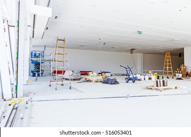 Used Wooden Ladder, Mobile Scaffold And Scissor Lift Platform Is Parked On An Indoor Construction Site.