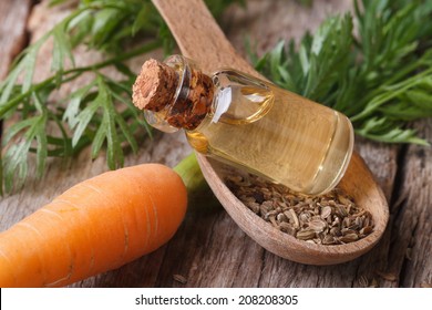 Useful Carrot Seed Oil In Glass Bottle On The Table Close-up Horizontal.  