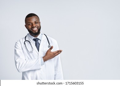 Useful Information. Happy African American Therapist Pointing At Copy Space, White Background