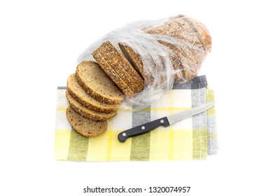 A useful, sliced, rye bread loaf with a variety of seeds and bran on a white background close-up