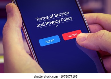User disagree with Terms of Service and the Privacy Policy mobile app. Finger presses the Cancel button on the phone screen. Dark theme, close-up