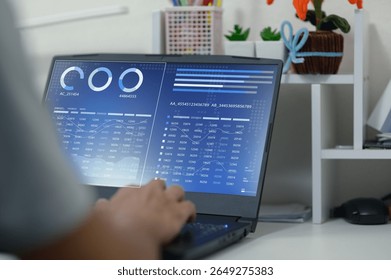 A user engages with a modern laptop featuring vibrant data visualizations and business elements, representing technology's role in analysis and productivity.