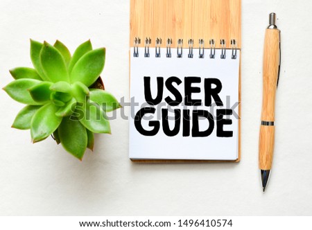 User guide text concept. Workplace with notebook, pen on wooden table.