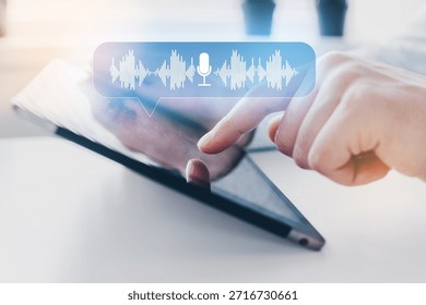 User interacting with touchscreen tablet to send voice message in a modern setting