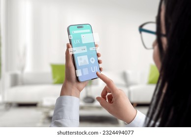 User interface and experience concept app on smart phone in woman hands. Clean design with flying app modules concept