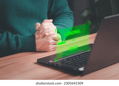User man using a laptop computer for download and update software with waiting to loading digital file data form website, very slow internet form wifi. Concept of waiting for load of loading symbol.