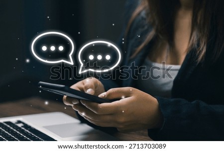 A user types on a smartphone with digital chat bubbles, representing online communication, instant messaging, customer interaction, social connection, and modern mobile communication technology.