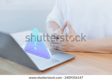 User use a computer laptop with caution warning sign for notification error. Concept of computer virus detected, personal data protection, network security, maintenance, cyber crime and cybersecurity.