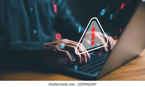 user is using computer with triangle caution warning sign for notification error and maintenance concept. hacker attacks and hacking data, cyber crime, cyber security, Ransomware, Phishing, Spyware.
