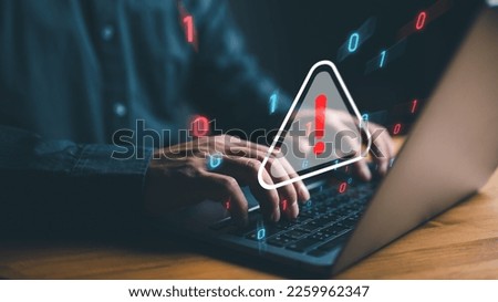 user is using computer with triangle caution warning sign for notification error and maintenance concept. hacker attacks and hacking data, cyber crime, cyber security, Ransomware, Phishing, Spyware.