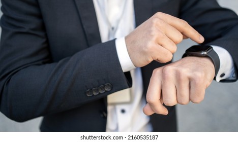 Uses a smartwatch businessman manager in a business suit in the office - Powered by Shutterstock