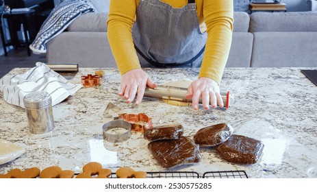 Using an adjustable rolling pin to roll out gingerbread cookie dough on the elegant marble counter in a modern kitchen, getting ready for festive holiday baking. - Powered by Shutterstock