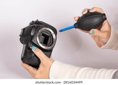 Using an air blower to clean a DSLR camera sensor