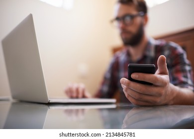 Using All The Latest Tech. Shot Of A Handsome Young Hipster Working On A Laptop.