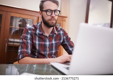 Using All The Latest Tech. Shot Of A Handsome Young Hipster Working On A Laptop.