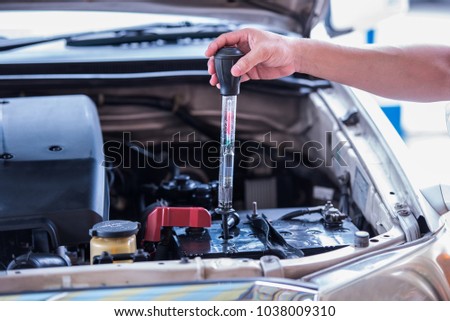 Using the battery hydrometer measuring gravity of battery distilled water, maintenance cars battery concept.