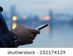Using cellphone with defocused city lights and river reflection.
