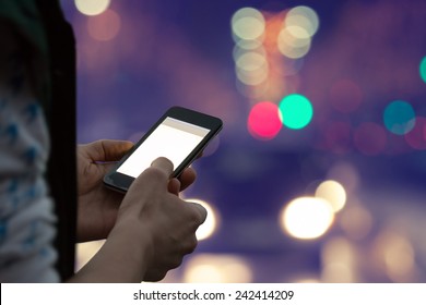 Using cellphone outdoors - with defocused city traffic. - Powered by Shutterstock