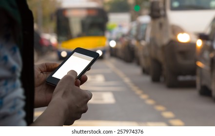 Using cellphone outdoors while waiting for the bus.