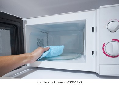 Using A Cloth To Clean A Microwave Oven 