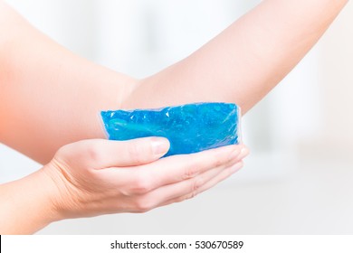 Using Cold Gel Compress On Elbow To Reduce Pain