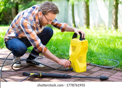 Using A Compact High Pressure Washer In The Garden, On Paving Stones.