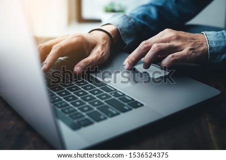 using computer.hand typing message on keyboard laptop chatting friend search information form internet while working on computer concept for technology device contact communication business people