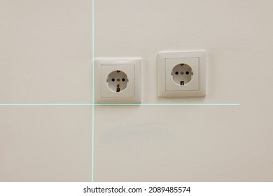 Using Cross Line Laser Level For Accurate Installation Of Outlet In White Wall