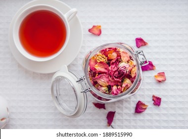 Using dry rose petals to make rose potpourri wich is great for home smell. Great way to preserving flowers and memories. Mason jar lid open filled with different color rose petals and tea cup with tea - Powered by Shutterstock