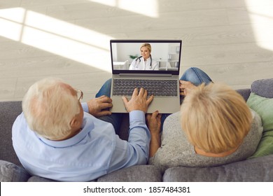 Using EHealth And Telemedicine Services At Home. Couple Of Senior Patients Sitting On Couch With Laptop Computer, Having Video Call With Online Doctor And Getting Professional Medical Consultation