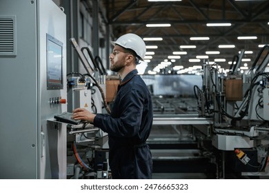 Using equipment, operator. Factory worker is indoors with hard hat. - Powered by Shutterstock