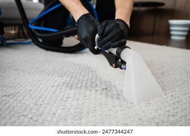 Using extractor to wash off the carpet from dust and stains. Extractor washing of carpet. Cleaner is using extractor to clean the carpet at home