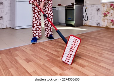 Using Flat Mop With Microfiber Pad To Mopping Floor In Kitchen During Housework.