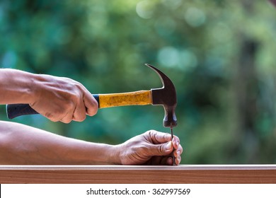 Using Hammer And Nail On Wood And Bokeh Background