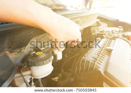 using hand to rotate lid for open and fill Brake fluid