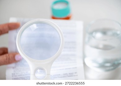 Using a handheld loupe to read small medication instructions. Highlights accuracy, careful review, and responsible medication management.