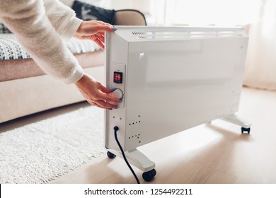 Using Heater At Home In Winter. Woman Regulating Temperature On Heater. Heating Season.