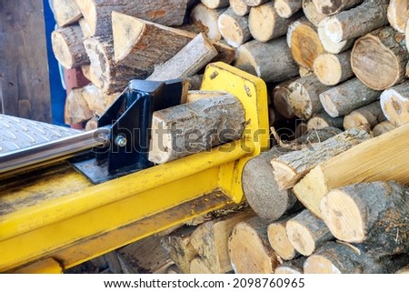 Using hydraulic splitter machine wood splitting a log