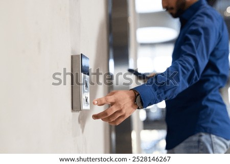 Using keycard, man accessing secure entry system of office building. Security, access control, technology, workplace, business, corporate