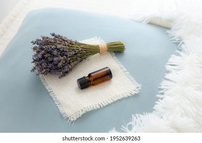 Using Lavender Flower Essential Oil For Better Good Night Sleep. Aromatherapy Concept. Lavender Oil And Bouquet Of Dried Lavender Flowers On Soft Pillow In Home Bedroom.