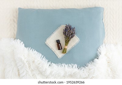 Using Lavender Flower Essential Oil For Better Good Night Sleep. Aromatherapy Concept. Lavender Oil And Bouquet Of Dried Lavender Flowers On Soft Pillow In Home Bedroom.