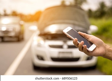 Using a mobile phone call a car mechanic because car was broken. - Shutterstock ID 689506123
