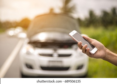 Using a mobile phone call a car mechanic because car was broken. - Shutterstock ID 689506135